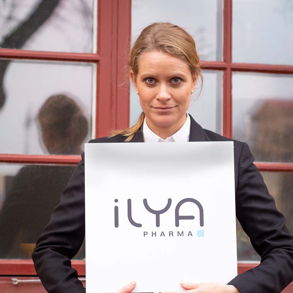 Evelina Vågesjö holding a sign saying Ilya Pharma